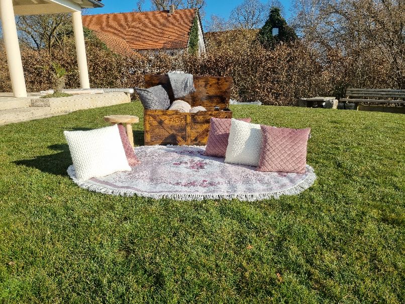 Lounge - Ecke mit Decken und Kissen, sowie einem Vintage Teppich