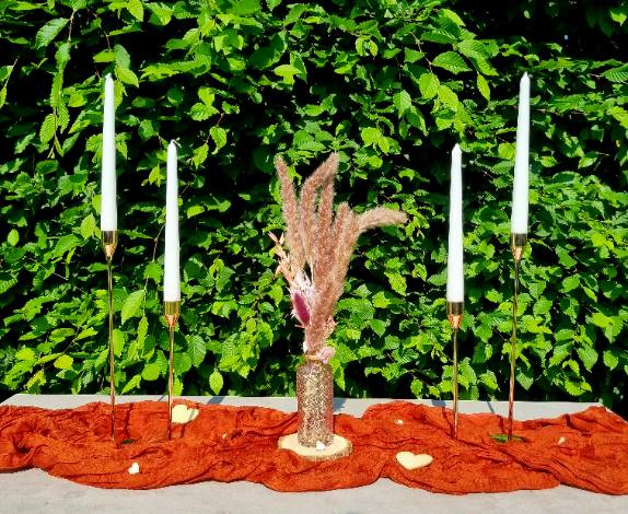 4 goldene Kerzenständer mit rosaner Vase